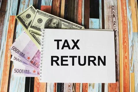 Notepad with text tax return on dollars and euros Stock Photos