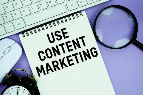 Notepad with the text "Use Content Marketing" and white keyboard, wireless .. Stock Photos