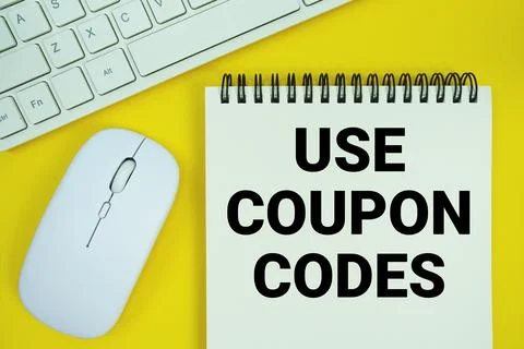 Notepad with the text "Use Coupon Codes" and white keyboard and wireless mo.. Stockfoto's