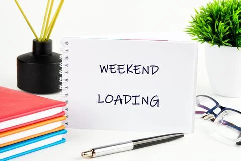 A notepad with Weekend loading written on it sits next to vibrant notebooks and Stock Photos