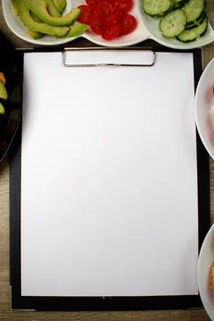 Notepad with a white sheet of paper for notes. Around a snack of crackers Stock Photos