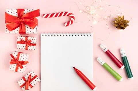 Notepad wish list on a pink table with felt-tip pens on a Christmas backgroun Stock Photos