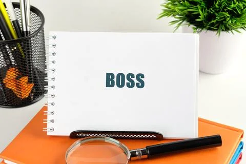 A notepad with the word BOSS printed on it rests on a stack of books. A 스톡 사진