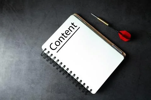 Notepad with word CONTENT and red dart arrow on black background Stock Photos