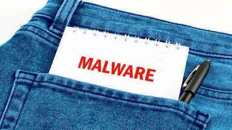 A notepad with the word malware written in bold red letters sits in the bac.. 스톡 사진