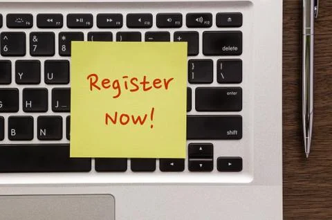 Notepad with words " Register Now " putting on laptop Foto stock