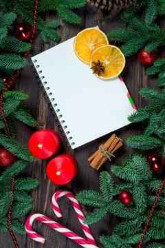 Notepad to write congratulations, dried orange, candles in a frame of lush sp Stock Photos