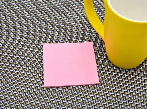 Notepad with yellow cup on pattern background Stock Photos