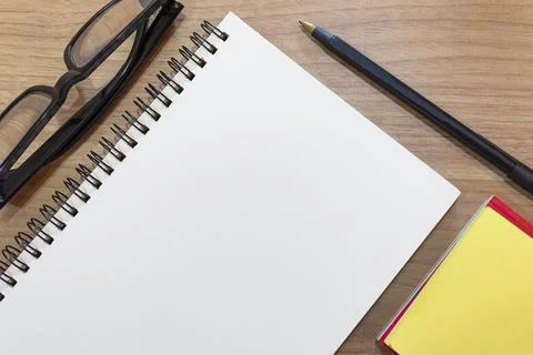 Notepad with yellow note and study glasses. Flat lay Фото