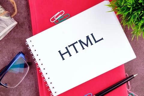 Notes on HTML are displayed on a notebook, surrounded by stationery items lik Foto stock
