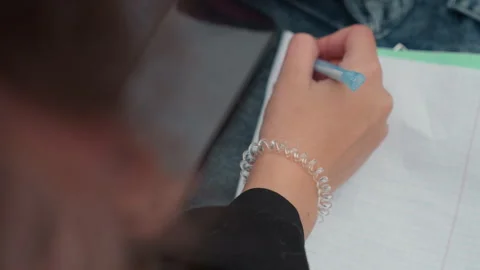 Notes jotted down on fresh paper. Casual student taking notes with quick Stock Footage 329887530