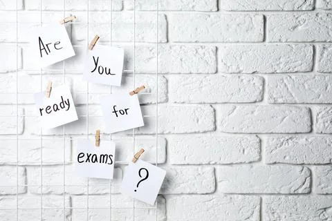 Notes with phrase Are you ready for exams hanging on white brick wall, spac.. Stock Photos