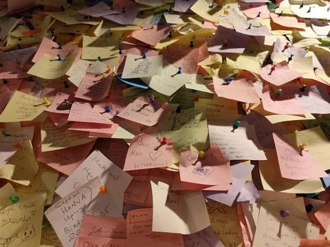 Notes on the wall. Sides of sheets of paper for notes attached with pins. Stock Photos