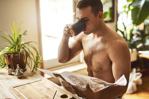 Nothing like a cup of java. a handsome young shirtless man drinking a cup of Stock Photos