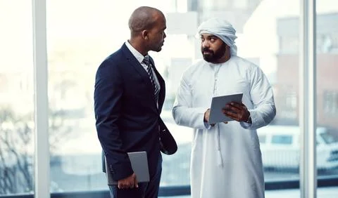 Nothing grows a business like working well together. two businessmen using a Stock Photos