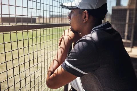 Nothing hypnotises him like baseball. Shot of a young man watching a game of Stock Photos