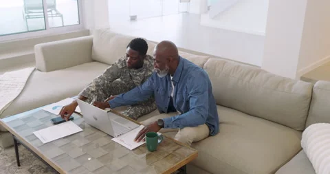 Noticing chart error, African American father and son typing on laptop and Stock Footage 314577689