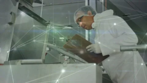 Noticing open hatch, tech inspecting food machine, noting on clipboard for Stock Footage 334185198