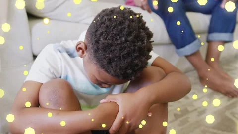 Noticing sore knees, child doing health check in living room, parent nearby, Stock Footage 333925467