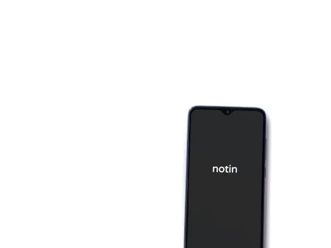 Notin app launch screen with logo on the display of a black mobile smartphone Stock Photos