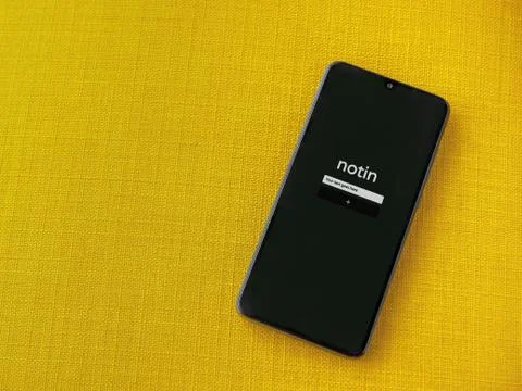Notin app launch screen with logo on the display of a black mobile smartphone Stock Photos