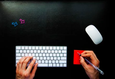 Noting while using keyboard on black desk with copy space Stock Photos