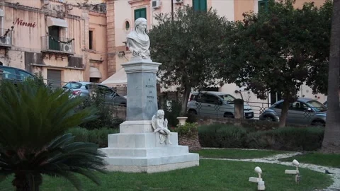 Noto sicily italy statue monument of person top half of body with grass trees Stock Footage 252155368