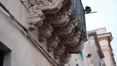 Noto sicily italy statue work of faces next to each other beneath balcony Video stock 252155453