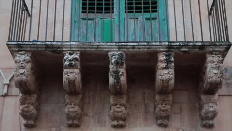 Noto sicily italy statue work of faces next to each other beneath balcony Video stock 252155464