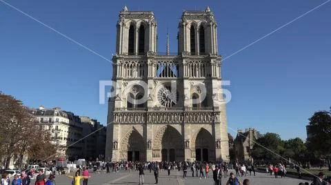 Notre Dame de Paris focus in to heat of art, people pass, blue serene sky Stock Photos