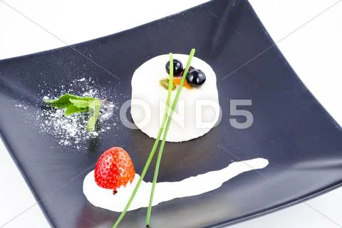 Nouvelle cuisine vanilla mousse dessert with cranberries on top Stock Photos