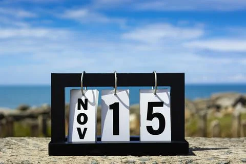 Nov 15 calendar date text on wooden frame with blurred background of ocean. Stock Photos