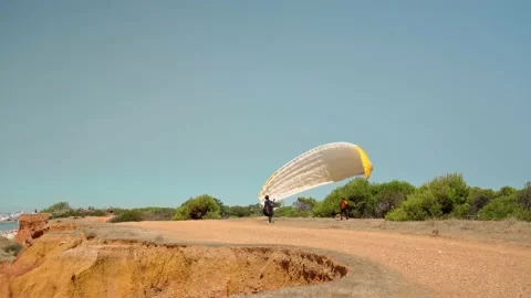A novice skydiver, with instructions from an instructor, is trying to lift a Stock Footage 172403339