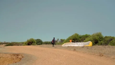 A novice skydiver, with instructions from an instructor, is trying to lift a Stock Footage 172481439