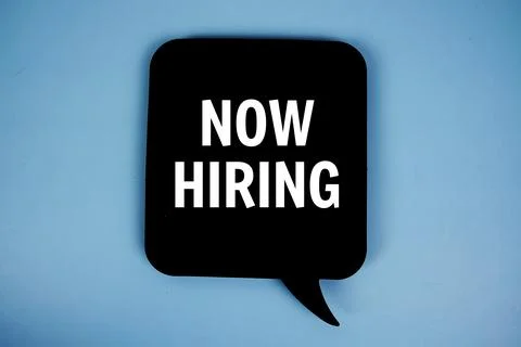 Now Hiring text with speech bubble top view on blue background Stock Photos