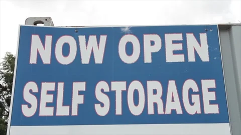 Now open self storage sign in white writing caption text against blue background Stock Footage 248715021