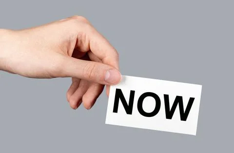 NOW reminder to do, memo note in hand Stock Photos