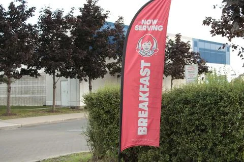 Now serving breakfast wendys restaurant logo banner vertical red white flag Stock Photos