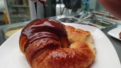 Nrecognizable person bathing a croissant Stock Footage 140620913