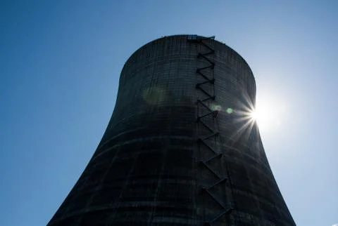 Nuclear cooling tower under a blue sky with a sunburst Stock Photos