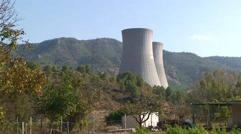 Nuclear cooling towers behind hill with pine forest Stock Footage 49965989
