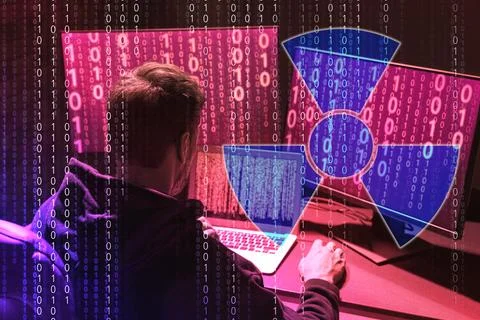 Nuclear deterrence. Hacker using computers, binary code and warning radiati.. Stockfoto's