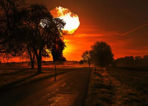 Nuclear explosion explodes behind the trees on the horizon. Third world nuc.. 库存照片