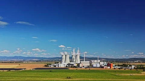 Nuclear power plant operating with cooling towers and steam in sunlight Stock Footage 344537366