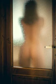 Nude female is behind the bath door Stock Photos