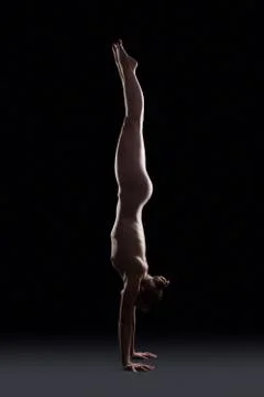 Nude gymnast posing in dark studio Stock Photos
