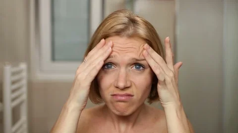 Nude woman frustrated while checking her skin in front of bathroom mirror. Stock Footage 79482228
