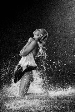Nuded model with black liquid getting water drops. Black and white. Photographie Stock Photos