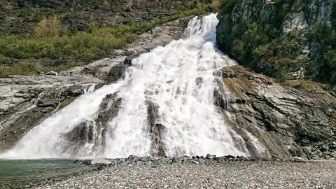 Nugget Falls over a beach on Mendenhall Lake Stock Footage 154384266