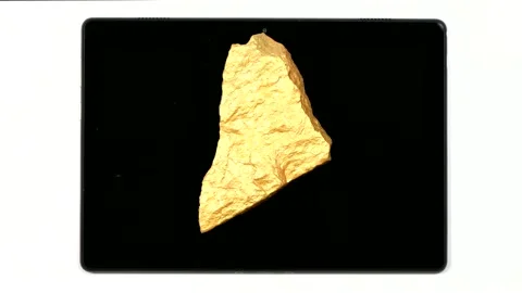 A nugget of gold moves across the surface of a tablet pc. Stock Footage 154814616